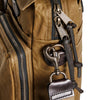 Close-up of a brown bag with metal hardware and straps.