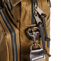 Close-up of a brown bag with metal hardware and straps.