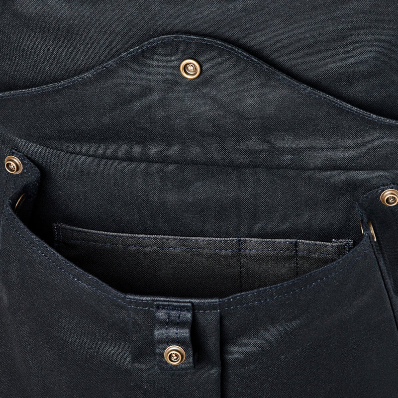 Close-up of a black pocket on backpack with button details on a white background