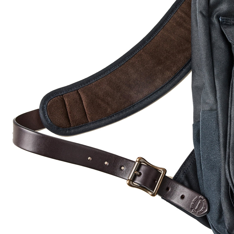 Close-up of a backpack with a brown leather strap and buckle on a white background