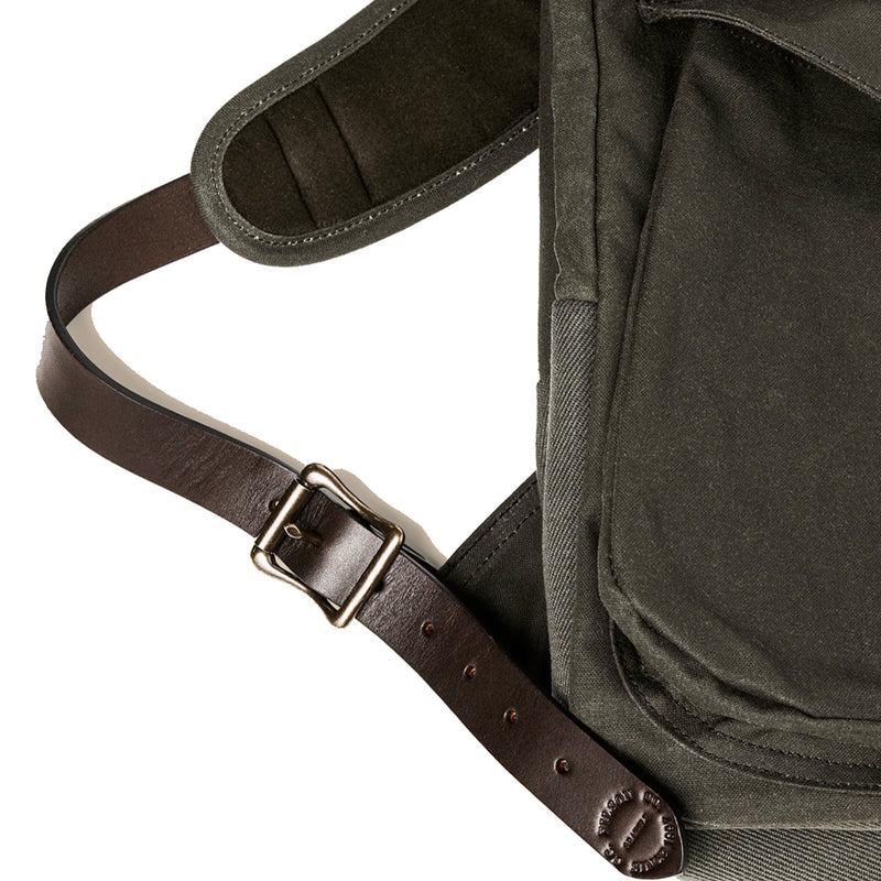 Green backpack with a brown leather strap and buckle on a white background