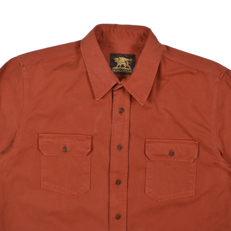 Orange shirt with two front pockets and a brand logo on the collar against a white background