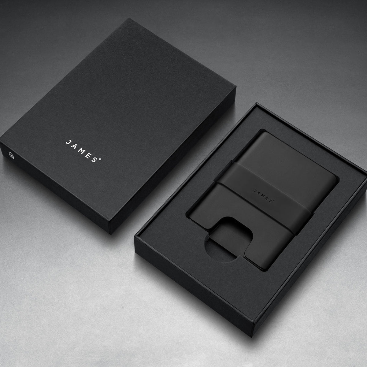 Black wallet and cardholder set with 'JAMES' branding on a gray background