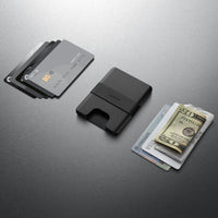Black cardholder with cards and money on a gray background