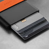 Cardholder with cards and a gold card on a gray surface