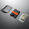 Black cardholder with orange accent on a gray surface with cards and money.