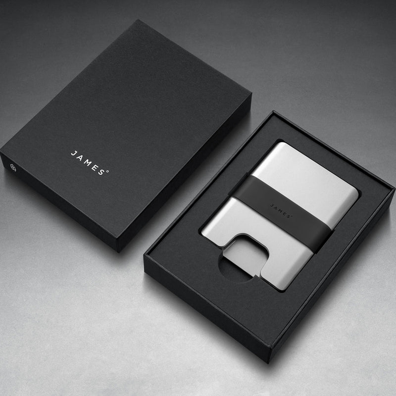 Silver wallet with black strap on a gray background