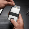 Silver wallet with black strap on a gray background