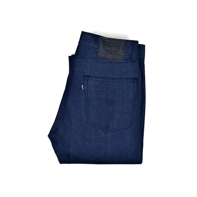 Folded Levi's blue jeans with a brand label on a white background