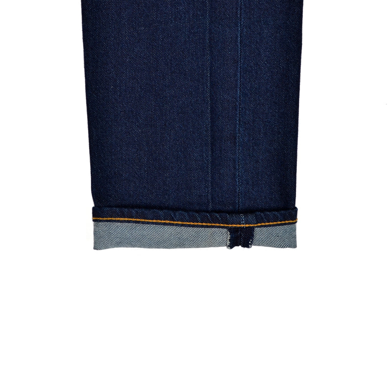 Close-up of dark blue denim fabric with a white background