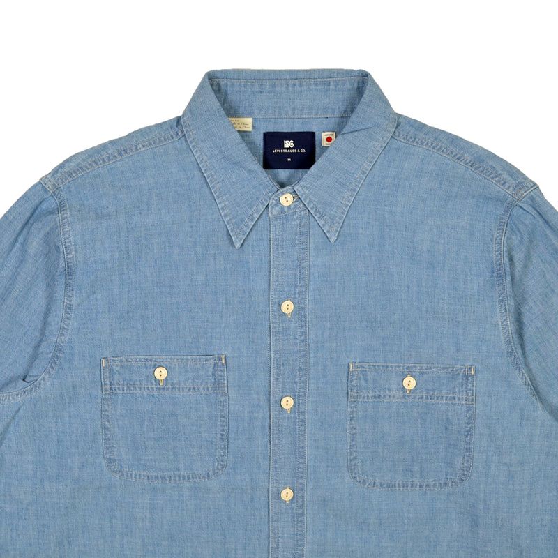 Blue denim shirt with button details on a white background