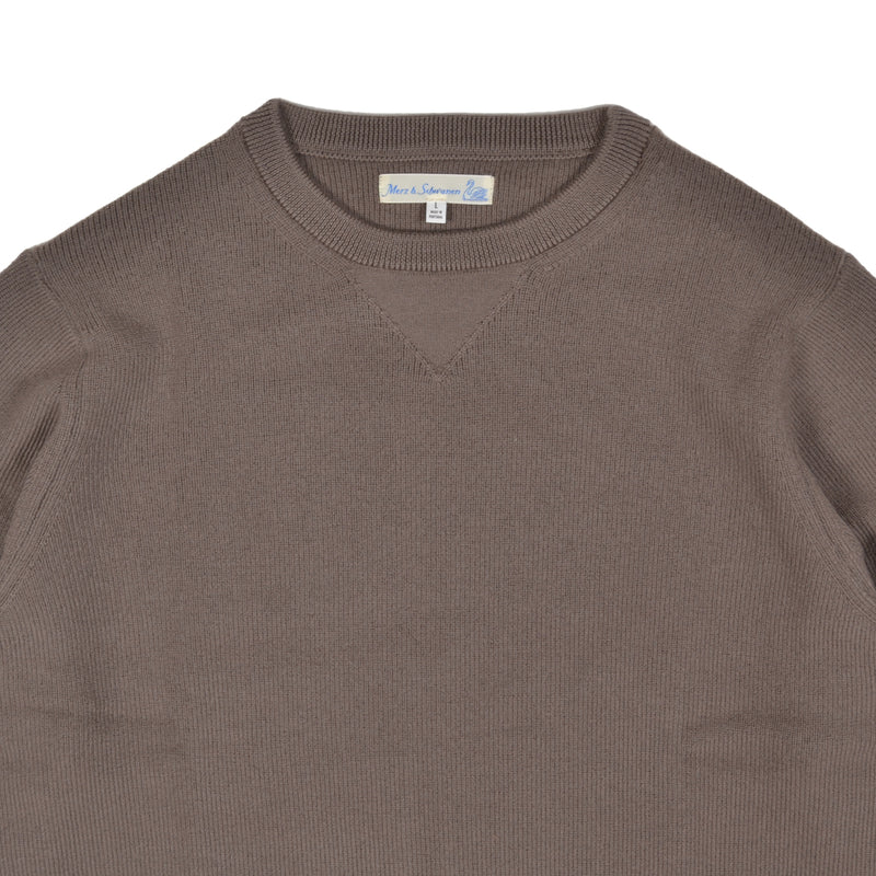Brown sweater with a visible brand label on a white background