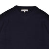 Close-up of a navy blue sweater with a brand label on a white background
