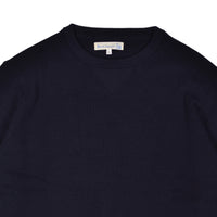 Close-up of a navy blue sweater with a brand label on a white background