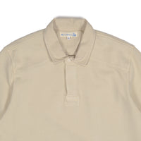 Beige polo shirt with a brand label on a white background