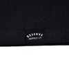 Close-up of a black fabric with 'Reserve Supply Co' logo.