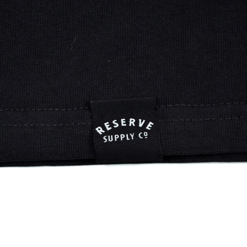 Close-up of a black fabric with 'Reserve Supply Co' logo.