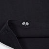 Close-up of a black shirt with a small logo on the collar.