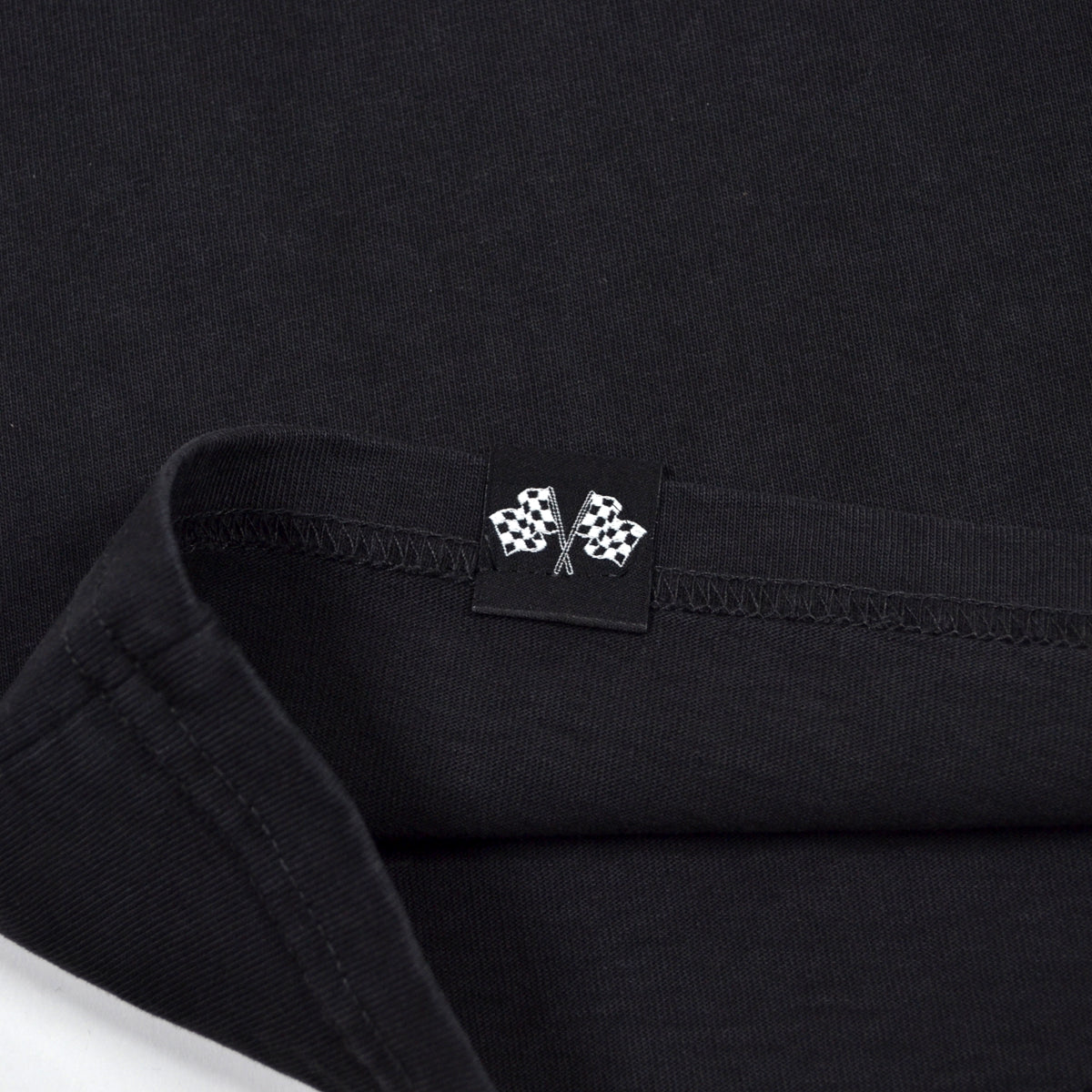 Close-up of a black shirt with a small logo on the collar.