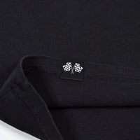 Close-up of a black shirt with a small logo on the collar.
