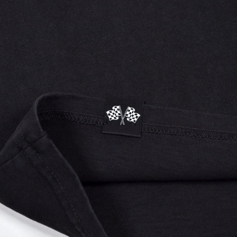 Close-up of a black shirt with a small logo on the collar.