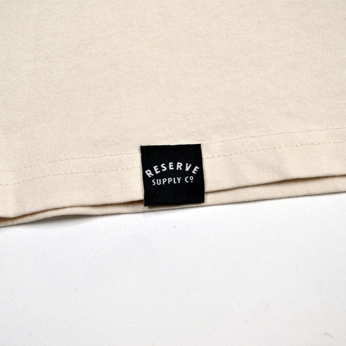 Beige fabric with a black label reading 'Reserve Supply Co' on a white background