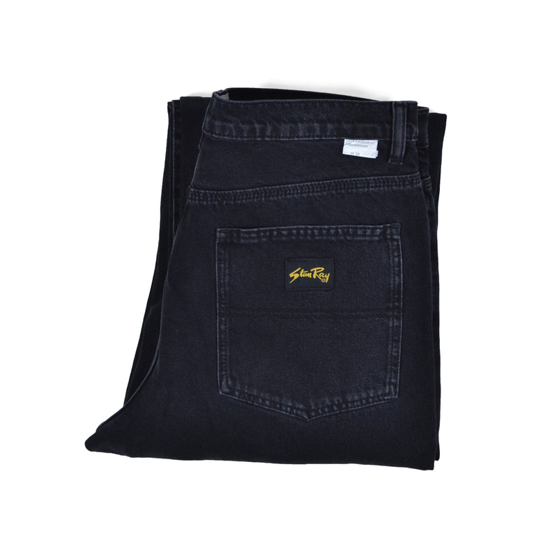 Folded black jeans with a brand logo on a white background