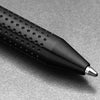 Black pen with textured grip on a gray surface
