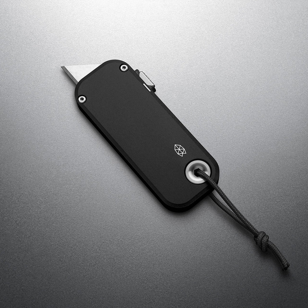 Black multi-tool with lanyard on a gray background