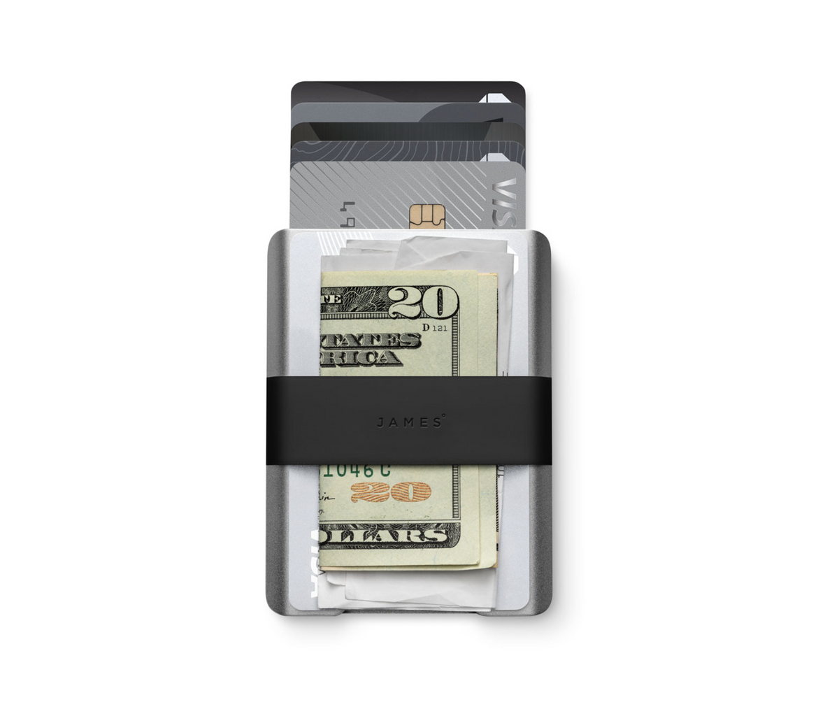 Silver wallet with black money clip on a gray background