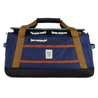 Blue duffel bag with brown straps and a Topo Designs logo on a white background