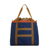 Blue tote bag with brown straps on a white background