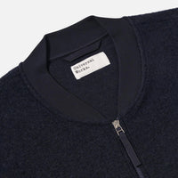 Close-up of a dark jacket with a visible brand label on a light gray background