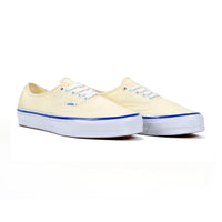Pair of off-white sneakers with blue soles on a white background