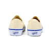 Pair of off-white sneakers with blue soles on a white background