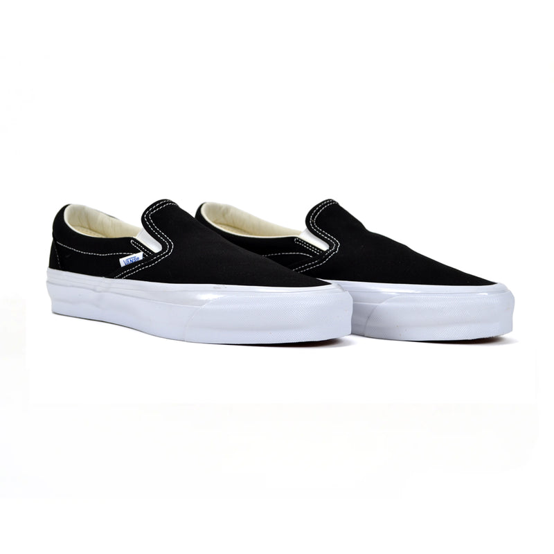 Black slip-on sneakers with white soles on a white background